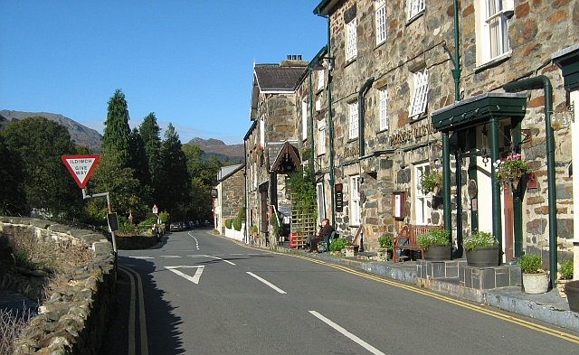 stone building on narrow road, price llewellyn pub in beddgelert in the sunshine